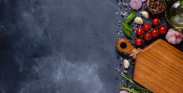 Herbs and condiments on black stone background