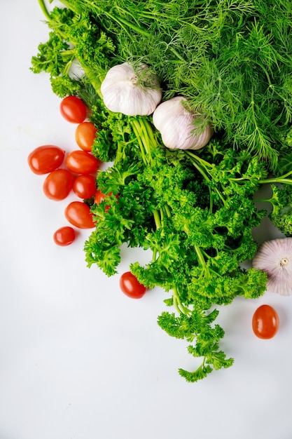 Photo herbs and garlic with tomato on white background. healthy meal.