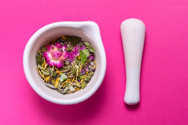 Herbs in porcelain mortar on colorful table