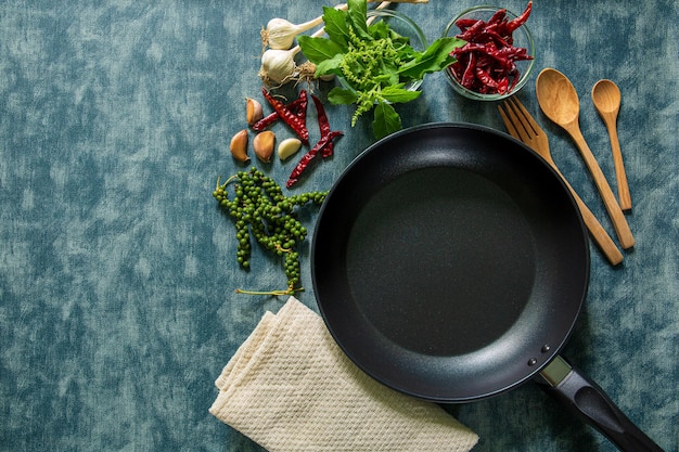 Herbs and spices around cast iron skillet on wooden background Cooking concept Top view copy spac