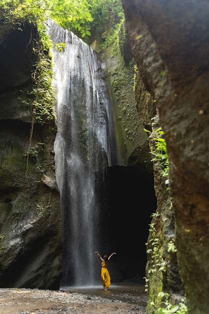 Here I am. Delighted tourist looking at waterfall while taking nice picture for good memory