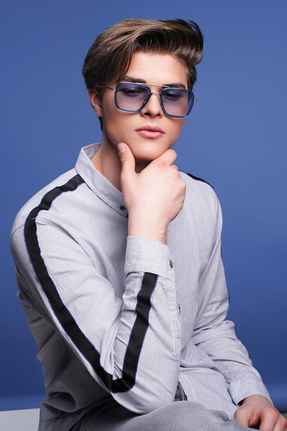 Herenaccessoires optiek hipster man zit in shirt in stijlvolle zonnebril studio portret