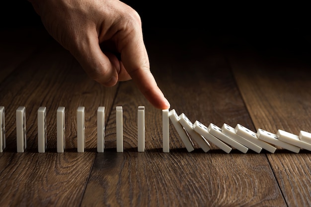 Herenhand gestopt domino-effect, op een bruin hout