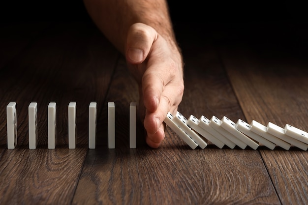 Herenhand gestopt domino-effect, op een bruin hout