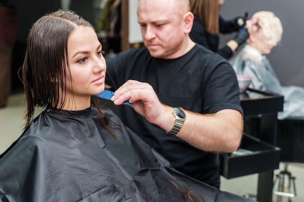 Herenkapper maakt nieuw kapsel in kapsalon.