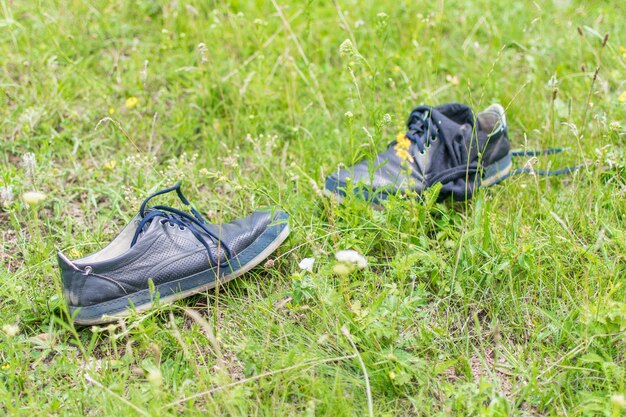 Herenschoenen uitgetrokken liggend op het groene gras Concept van rust