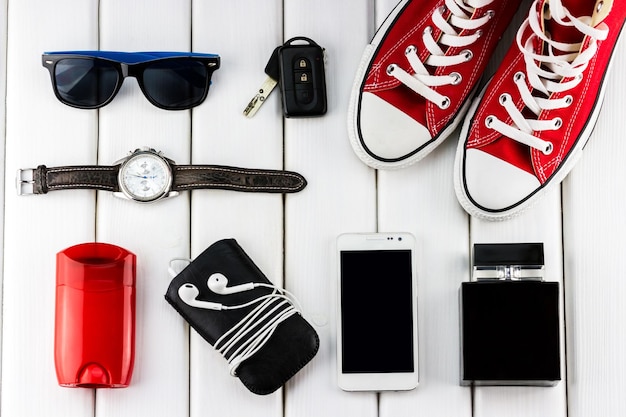 Herensneakers en een smartphone met een horloge