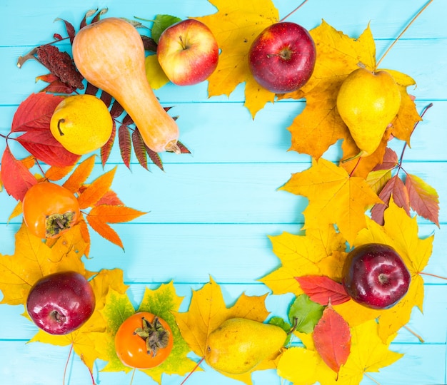 Herfst achtergrond met bladeren en oogst op blauwe houten bureau met kopie ruimte.