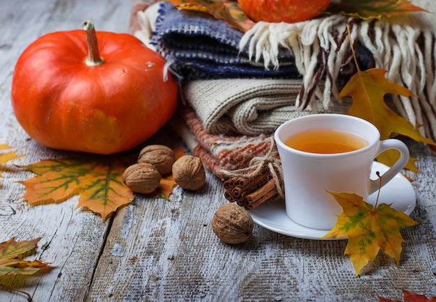 Herfst achtergrond met bladeren, pompoen en een kopje thee