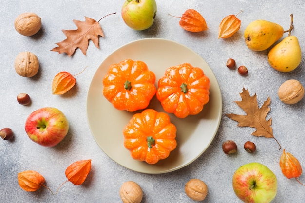 Herfst achtergrond met gele bladeren, pompoenen appels peren en noten