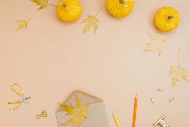 Herfst achtergrond met gele pompoenen gevallen bladeren koekjes kleurpotloden eon en een pen