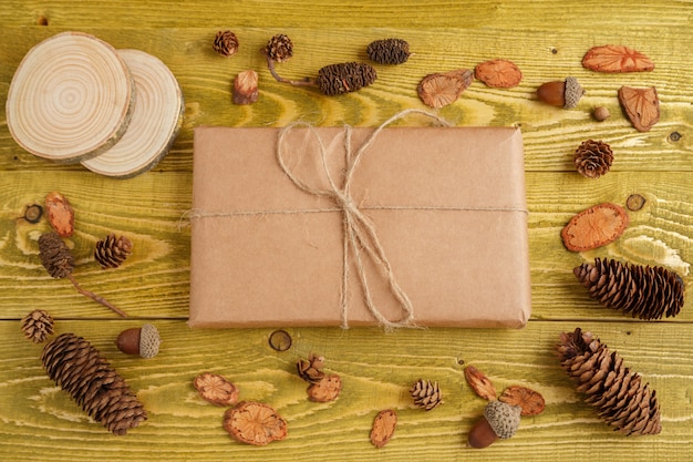 Herfst achtergrond. plat leggen. stukjes hout, kegels, eikels en pakket Verpakt in Kraft-papier op groene grunge houten achtergrond