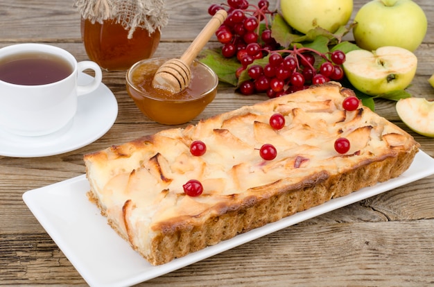 Herfst appeltaart met viburnumbessen op houten tafel.