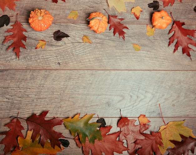 Herfst arrangement van kleurrijke bladeren, pompoen, eikel, kastanje fruit op een houten achtergrond met vrije ruimte voor tekst. bovenaanzicht, seizoensconcept, getint retro-effect, plat gelegd