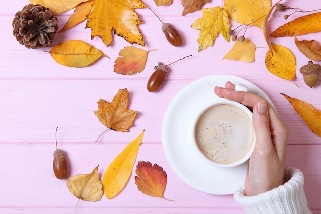 Herfst compositie bovenaanzicht kopje koffie in de handen en herfstbladeren