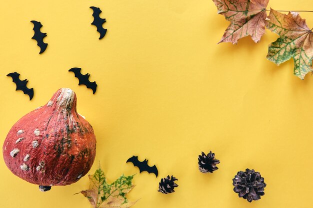 Herfst compositie. Frame gemaakt van pompoenen, gedroogde bladeren, dennenappels en vleermuizen achtergrond. Sjabloon herfst, herfst, halloween, oogst thanksgiving concept. Plat leggen, bovenaanzicht, ruimtebanner kopiëren