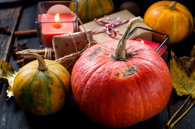 Herfst compositie met kaarsen, pompoenen en herfstbladeren, kopje thee op donkere houten rustieke tafel. Thanksgiving en halloween vakantie. Herfst seizoen concept. Herfst stilleven. plat leggen, ruimte kopiëren