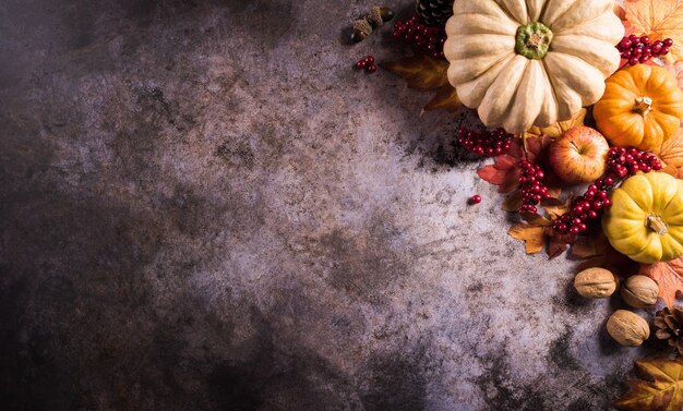 Herfst compositie. Pompoen, herfstbladeren en appel op donkere stenen achtergrond. Platliggend, bovenaanzicht met kopieerruimte.