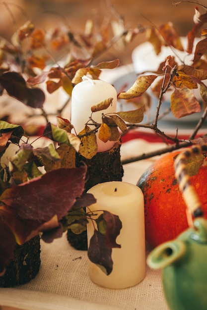 Foto herfst decor met pompoen, kaarsen en servies