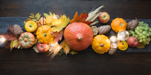 Herfst decor voor Thanksgiving Day met pompoenen, bladeren, appels, lichten op houten tafel