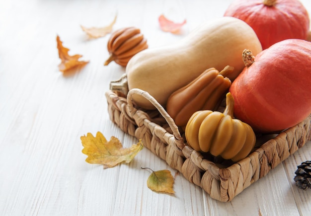 Herfst decoratieve pompoenen met herfstbladeren op houten achtergrond