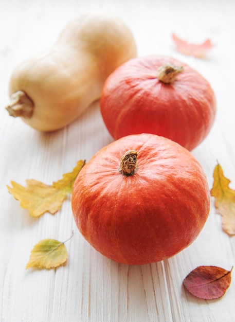 Herfst decoratieve pompoenen met herfstbladeren op houten achtergrond