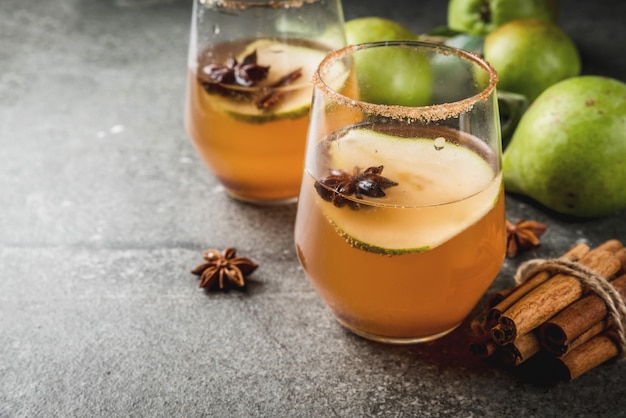 Herfst drankjes. Glühwein. Traditionele herfst kruidige cocktail met peer, cider en chocoladesiroop, met kaneel, anijs, bruine suiker. Op zwarte stenen tafel. copyspace