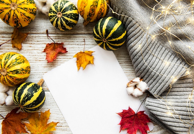 Herfst esdoorn bladeren, pompoenen en wollen sjaal op een houten achtergrond. Herfst achtergrond.