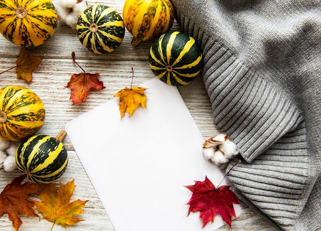 Herfst esdoorn bladeren, pompoenen en wollen sjaal op een houten