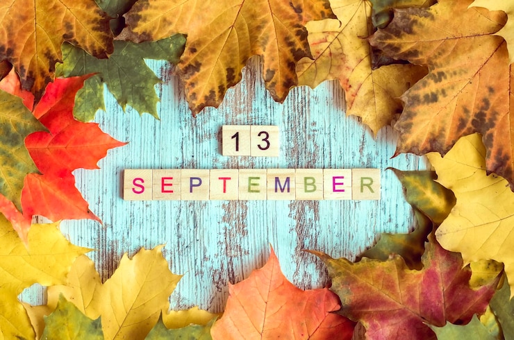 Foto herfst esdoorn gebladerte inscriptie 13 september in houten letters op de herfst tafelachtergrond