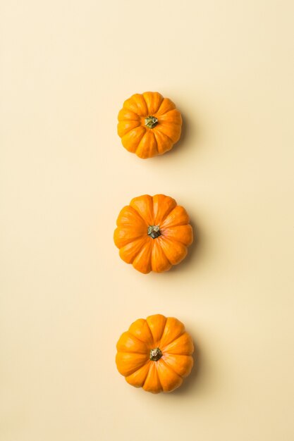 Herfst herfst Thanksgiving dag samenstelling met decoratieve oranje pompoenen. Plat lag, bovenaanzicht, kopieer ruimte, stilleven gele achtergrond voor wenskaart