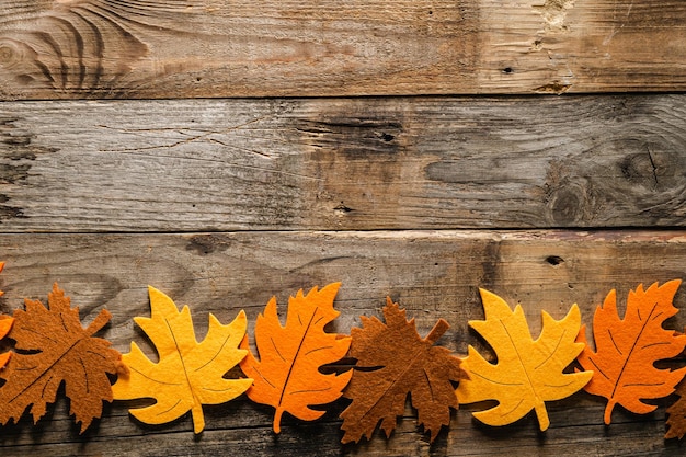 Herfst houten achtergrond met gekleurde vilten bladeren