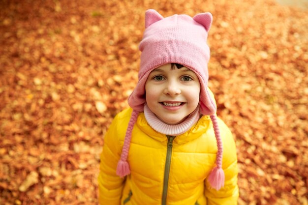 herfst, jeugd, natuur en mensen concept - gelukkig meisje over gevallen bladeren in park