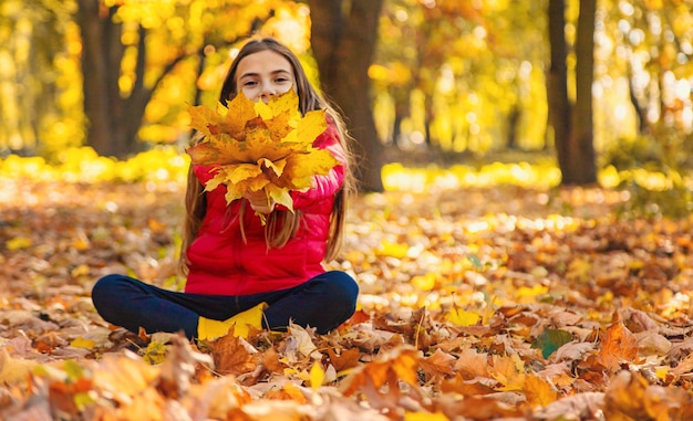 Herfst kind in het park met gele bladeren Selectieve aandacht Kid