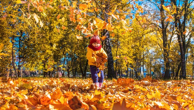 Herfst kind in het park met gele bladeren Selectieve aandacht Kid