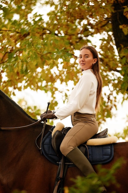 Herfst landschap mooi brunette meisje met lang haar poseren met een rood paard in het bos