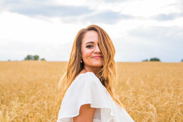 Herfst meisje genieten van de natuur op het veld. Gratis gelukkige vrouw.