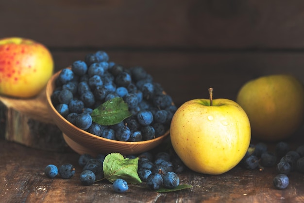 Herfst oogst blauwe sleedoornbessen op een houten tafel achtergrond Kopieer ruimte Donkere rustieke stijl Natuurlijke remedie