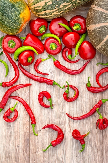 Herfst oogst groenten Pompoen rode en groene paprika's op een houten ondergrond