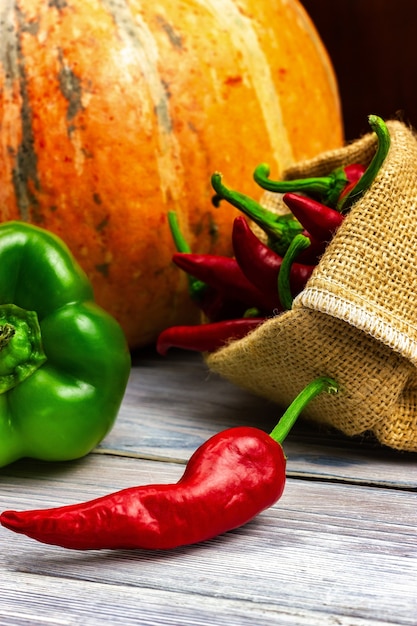 Herfst oogst pompoen peper op een licht houten tafel