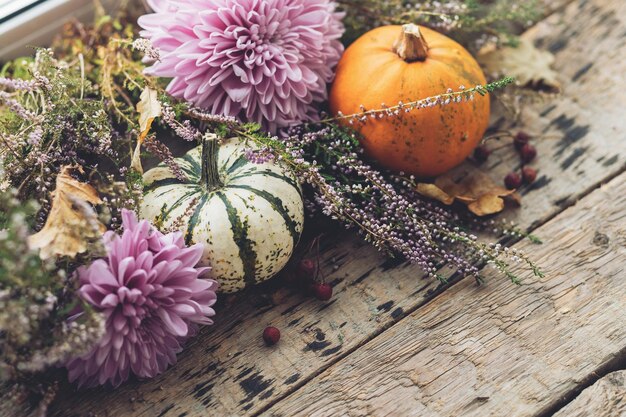 Herfst op het platteland Stijlvolle pompoenen paarse dahlia's bloemen heide op rustiek oud hout