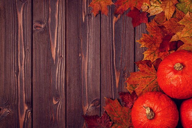 Herfst oppervlak met gekleurde bladeren en pompoenen op houten oppervlak