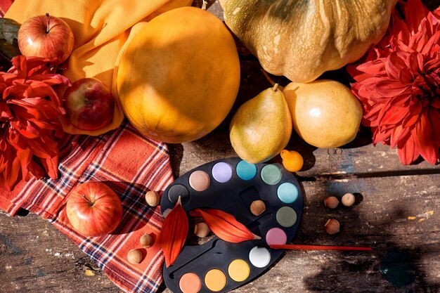 Herfst plat gele fruit groenten en heldere verven met een borstel pompoen peren appel en meloen Herfst stilleven met rode georgine moderne schaduwen