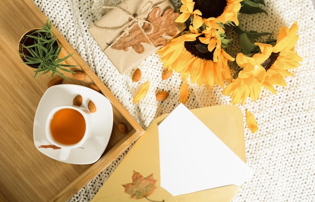 Herfst plat met mockup brief in gouden envelop thee zonnebloemen en cadeau