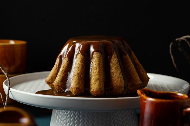 Herfst pompoen bundt cake met gebakken maanzaad en karamel op een donkere achtergrond