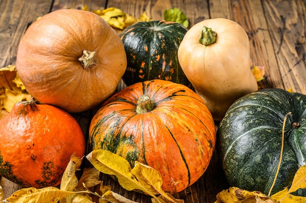 Herfst pompoenen met esdoorn bladeren op houten tafel. Houten tafel. Bovenaanzicht.