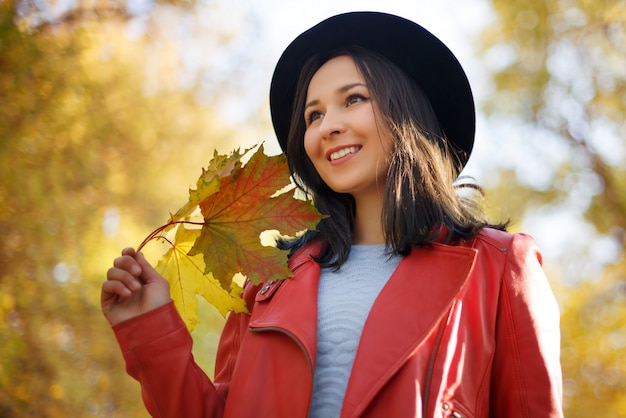Foto herfst portret van een meisje vrouw in een hoed en rode jas