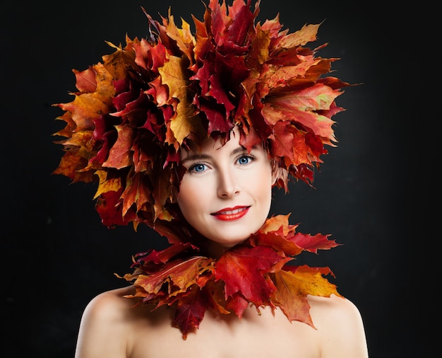 Herfst portret van gelukkige vrouw met herfstbladeren op zwarte achtergrond