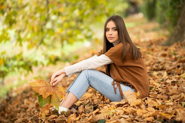 Herfst romantiek vrouw met bladeren vrouwelijk model op gebladerte dagdroom en levensstijl schoonheid buitenpoort