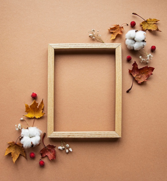 Herfst samenstelling. fotolijst, bloemen, bladeren op bruine achtergrond. herfst, herfst, thanksgiving day concept.